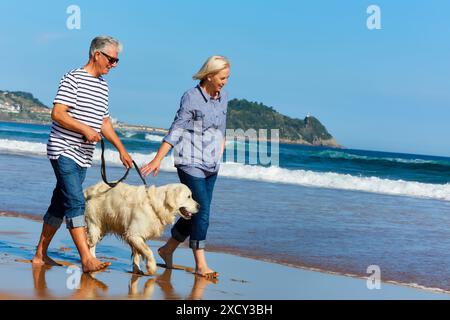 Seniorenpaar, 60-70, Spaziergang mit Hund am Strand, Hintergrund Getaria, Zarautz, Gipuzkoa, Baskenland, Spanien, Europa Stockfoto