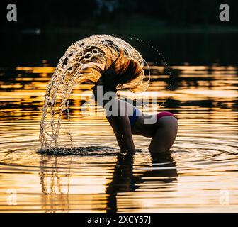 Langhaarige Frau, die im See planscht Stockfoto
