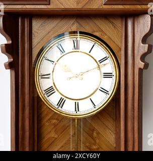 Eine antike, an der Wand montierte Großvateruhr aus Holz mit römischen Ziffern und einer Glastür auf weißem Hintergrund - 3D-Rendering Stockfoto