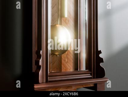 Eine antike, an der Wand montierte Großvateruhr aus Holz mit römischen Ziffern und einer Glastür auf einem schwach beleuchteten Innenhintergrund - 3D-Rendering Stockfoto