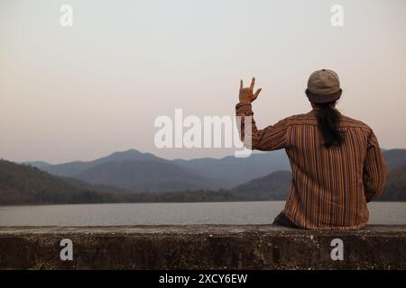 Der Mann benutzt Gebärdensprache Ich liebe dich, um seine Liebe und Freundschaft auszudrücken, seinen Freund und Geliebten. Gebärdensprache, die das Symbol „Ich liebe dich“ zeigt, um die Liebe f auszudrücken Stockfoto