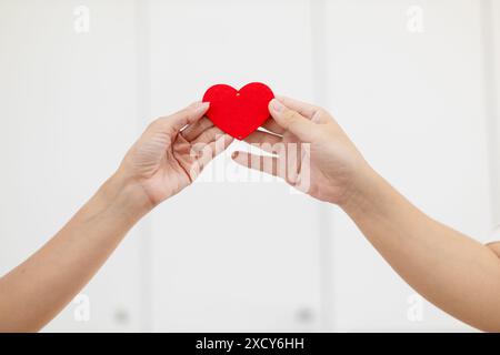 Paare zeigen zusammen herzförmige Symbole, um ihre Liebe und Freundschaft zueinander an ihrem großen Tag zu zeigen. Handgeformtes Herzsymbol für Ex Stockfoto