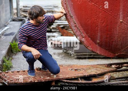 Junger Mann zu Fuß in der Werft, Schiff im Hafen von Pasaia, Gipuzkoa, Baskenland, Spanien, Europa Stockfoto