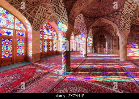 Shiraz, Iran - 31. Oktober 2018: Farbenfroher Blick auf das Morgensonnenlicht, das durch Buntglasfenster auf Säulen, Wand und Boden reflektiert wird. Stockfoto