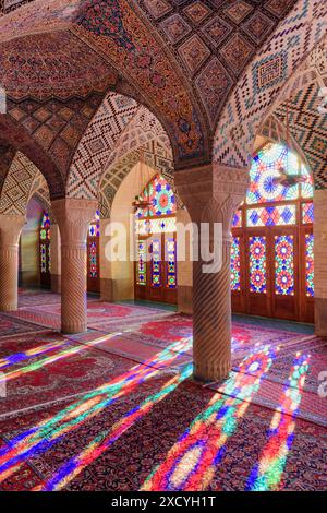 Shiraz, Iran - 31. Oktober 2018: Farbenfroher Blick auf das Morgensonnenlicht, das durch Buntglasfenster auf Säulen, Wand und Boden reflektiert wird. Stockfoto