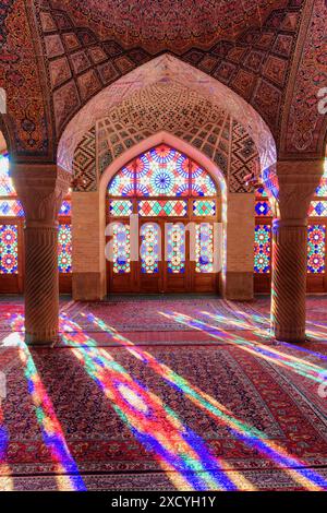 Shiraz, Iran - 31. Oktober 2018: Farbenfroher Blick auf das Morgensonnenlicht, das durch Buntglasfenster auf Säulen, Wand und Boden reflektiert wird. Stockfoto