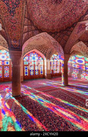 Shiraz, Iran - 31. Oktober 2018: Farbenfroher Blick auf das Morgensonnenlicht, das durch Buntglasfenster auf Säulen, Wand und Boden reflektiert wird. Stockfoto