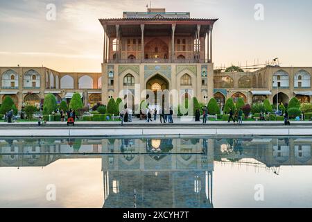 Isfahan, Iran - 24. Oktober 2018: Fantastischer Blick auf den Ali Qapu Palast auf dem Naqsh-e Jahan Platz bei Sonnenuntergang. Die Fassade spiegelt sich im Wasser. Stockfoto