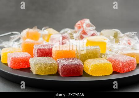 Verschiedene Gelee-Bonbons auf schwarzem Tablett. Stockfoto