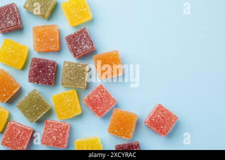 Verschiedene Gelee-Bonbons auf blauem Hintergrund, Draufsicht. Stockfoto