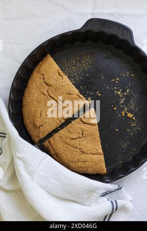 Flachbild-Fotografie der traditionellen estnischen Gerste Scone (Odrakarask) Restscheiben in schwarzer Keramikform mit einem weißen Küchentuch Stockfoto