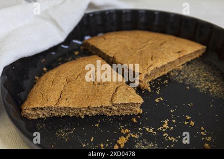 Nahaufnahme der traditionellen estnischen Gerstenschnecke (Odrakarask) in schwarzer Keramikform mit einem weißen Küchentuch Stockfoto