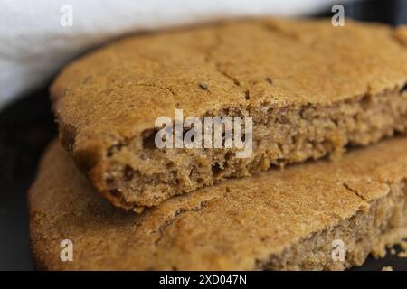 Nahaufnahme der traditionellen estnischen Barley Scone (Odrakarask) Textur in schwarzer Keramikform mit einem weißen Küchentuch Stockfoto