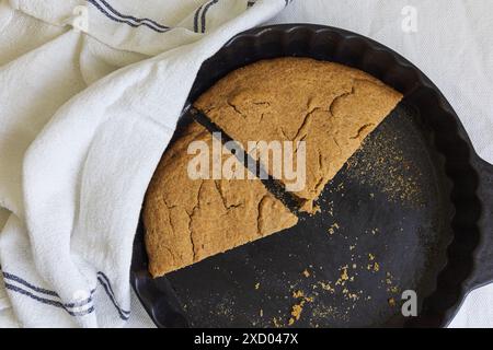 Flachbild-Fotografie der traditionellen estnischen Gerste Scone (Odrakarask) Restscheiben in schwarzer Keramikform mit einem weißen Küchentuch Stockfoto