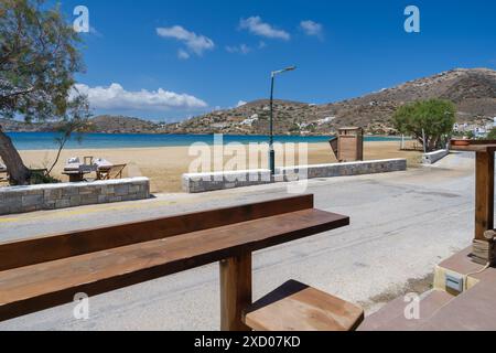 IOS, Griechenland - 5. Mai 2024 : Blick auf die Tische und Stühle einer Strandbar neben Bäumen am Gialos Beach in iOS Griechenland Stockfoto