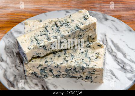 Gorgonzola-Käse, Scheiben typisch italienischer Blauschimmelkäse auf Marmorplatte auf Holztisch Stockfoto