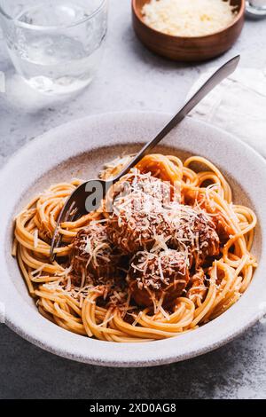 Spaghetti mit Fleischbällchen, Tomatensauce und Parmesankäse auf grauem Hintergrund, Nahaufnahme Stockfoto