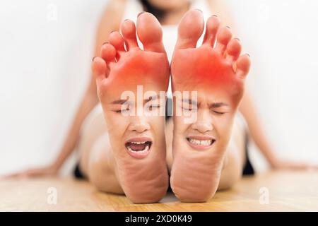 Die Füße einer Frau sind mit einer roten Markierung gekennzeichnet. Die Frau ist in einer Pose, die aussieht, als hätte sie Schmerzen Stockfoto