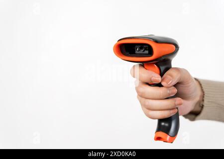 Eine Person hält einen schwarz-orangefarbenen Strichcode-Scanner in der Hand. Konzept von Technologie und Moderne Stockfoto