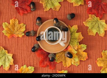 Buntes Herbst- oder Herbstmuster mit Herbstblättern, Nüssen und einer Tasse Kaffee auf braunem Musselin Hintergrund. Minimales saisonales Konzept. Natur flach gelegen. Stockfoto