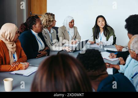 Vielfältige Gruppe von Fachleuten bei Geschäftstreffen. Teammitglieder diskutieren Ideen an einem Konferenztisch und betonen Teamarbeit und Zusammenarbeit. Stockfoto