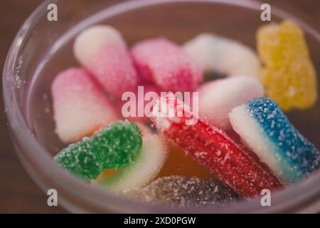 Süße Süßigkeiten in verschiedenen Farben in einer Glasschale aus nächster Nähe. Viele bunte Gummibonbons. Makrofoto für Lebensmittel. Jelly süßer Snack auf einem Tisch. Stockfoto