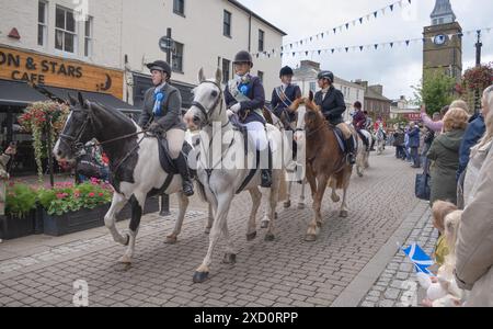 Im Rahmen der GUID Nychburris-Events am 15. Juni 2024 machen sich Reiter zu Pferd auf den Weg entlang der Dumfries High Street im Stadtzentrum Schottlands. Stockfoto