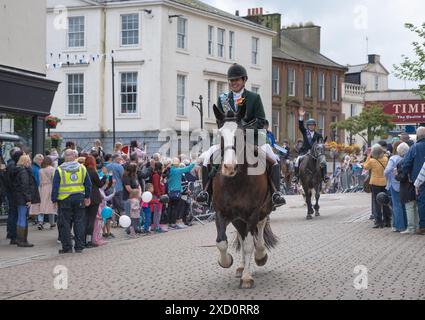 Am 15. Juni 2024 machen sich im Rahmen der GUID Nychburris-Veranstaltungen weitere Reiter auf dem Pferderücken auf den Weg entlang der Dumfries High Street, im Stadtzentrum Schottlands. Stockfoto