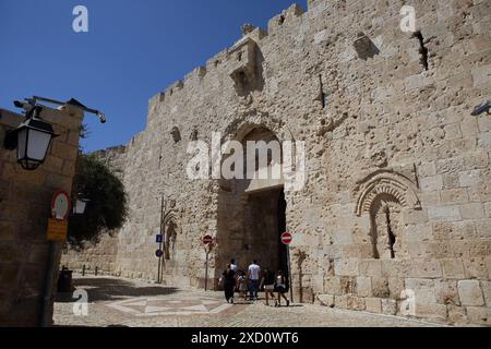 Die Menschen betreten das Zion-Tor, eines von acht Toren zur Altstadt von Jerusalem. Die Löcher um das Tor erinnern an die Schießerei des israelischen Unabhängigkeitskrieges Stockfoto