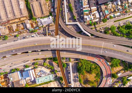 Mehrstöckiger Kreuzungsübergang zwischen Autobahn, Schnellstraße und elektrischer S-Bahn-Bahn in städtischen Gebieten mit Draufsicht. Stockfoto