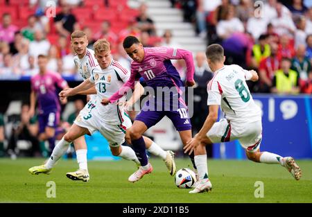 Der deutsche Jamal Musiala im Kampf gegen den Ungarn Andras Schafer (links) und den Ungarn Adam Nagy (rechts) beim Spiel der UEFA Euro 2024 Gruppe A in der Stuttgart Arena. Bilddatum: Mittwoch, 19. Juni 2024. Stockfoto