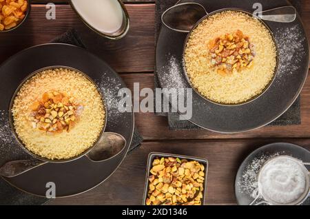 Arabische Küche; süßes Couscous Rezept ist ein nordafrikanisches Frühstücksgericht namens „Mesfouf“. Serviert mit Nüssen, Zucker und Buttermilch. Stockfoto