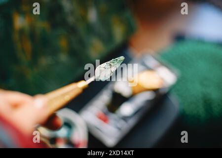 Eine Nahaufnahme eines Palettenmessers mit grüner Farbe im Atelier eines Künstlers Stockfoto