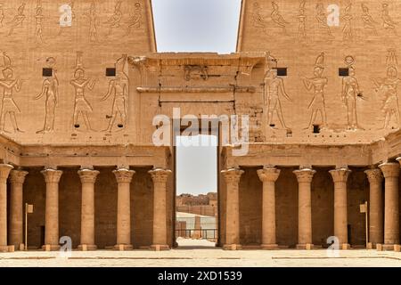Altägyptischer Tempel mit detaillierten Schnitzereien und Säulen unter klarem Himmel. Stockfoto