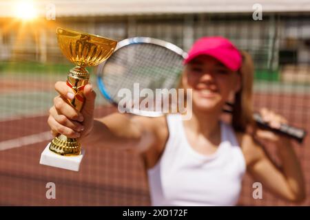 Begeisterte junge Tennisspielerin feiert Sieg auf der Karte, Tennis Cup, Sieg im Tennis, großes Tenniskonzept Stockfoto