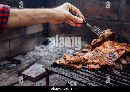 Argentinisches Asado auf dem Grill mit verschiedenen Fleischstücken. Typisches argentinisches Essen mit Rindfleisch und Wurst. Stockfoto