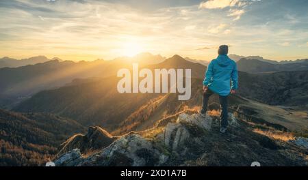 Mann auf Stein auf dem Hügel und wunderschönes Bergtal Stockfoto