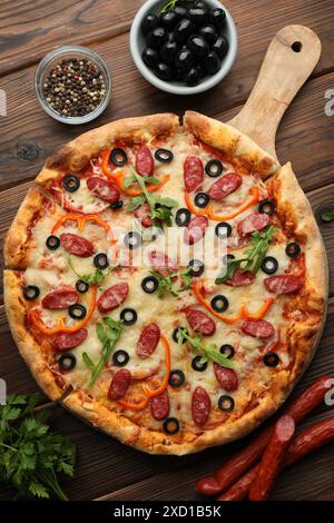 Leckere Pizza und Zutaten auf Holztisch, Blick von oben Stockfoto