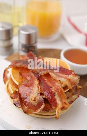 Leckere Pfannkuchen mit Speck und Honig auf dem Tisch, Nahaufnahme Stockfoto