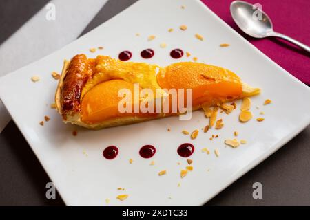 Scheibe Pfirsichcreme-Puddingtörtchen mit Mandelscheiben Stockfoto