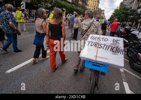 Barcelona, Spanien. Juni 2024. Während der Demonstration wird ein Demonstrant mit einem Plakat auf seinem Fahrrad gesehen, das gegen die massiven Tourismusaktivitäten in Barcelona gerichtet ist. Tausende von Menschen haben sich in der Aragón-Straße versammelt, um gegen die Formel-1-Autoausstellung und das Fan-Festival im Stadtzentrum zu protestieren, das enorme Staus und Luftverschmutzung verursacht hat. Die Demonstranten fordern, dass die Stadt nicht an große elitäre Handelsmarken verkauft werden darf. (Foto: Paco Freire/SOPA Images/SIPA USA) Credit: SIPA USA/Alamy Live News Stockfoto