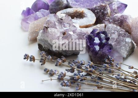 Wunderschöne violette natürliche Amethyst-Kristalle und getrocknete Lavendelblüten. Stockfoto