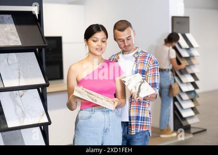 Ein paar Männer und Frauen wählen Kacheln im Laden Stockfoto