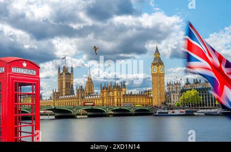 Britische Flagge und traditionelle Londoner Telefonzelle neben dem berühmten Big Ben (Elisabeth Tower) und dem Parlamentsgebäude in London, Großbritannien Stockfoto