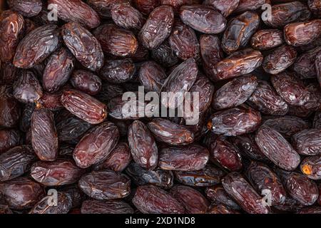 Vollformat-Hintergrundansicht von oben auf dem Stapel von appetitlich getrockneten Dattdato-Medjoul-Früchten, die auf der Oberfläche angeordnet sind Stockfoto