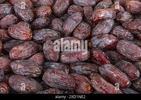 Vollformat-Hintergrundansicht von oben auf dem Stapel von appetitlich getrockneten Dattdato-Medjoul-Früchten, die auf der Oberfläche angeordnet sind Stockfoto