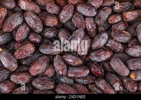 Vollformat-Hintergrundansicht von oben auf dem Stapel von appetitlich getrockneten Dattdato-Medjoul-Früchten, die auf der Oberfläche angeordnet sind Stockfoto