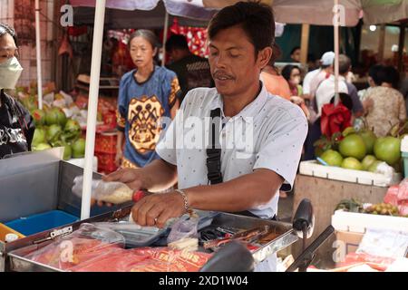 Ein Straßenhändler bereitet seine Waren auf einem traditionellen Markt in Chinatown Petak 9, Glodok, Jakarta zu Stockfoto