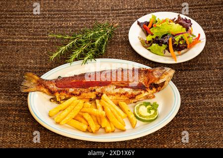 Gebackene Forelle mit Pommes Frites - Regenbogenforelle vom Tota Boyaca See. Kolumbianische Gastronomie Stockfoto