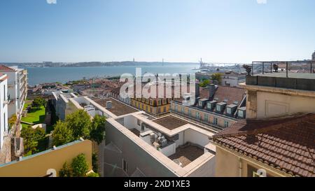 Ein Panoramablick auf Lissabon mit dem Fluss Tejo, der Brücke 25 de Abril und dem Christus-König-Denkmal. Der Vordergrund zeigt traditionelle Gebäude Stockfoto